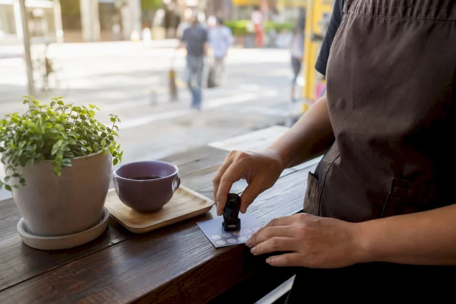 Barista stamping loyalty card in café