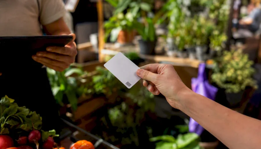 Hand holding plastic loyalty card with QR code