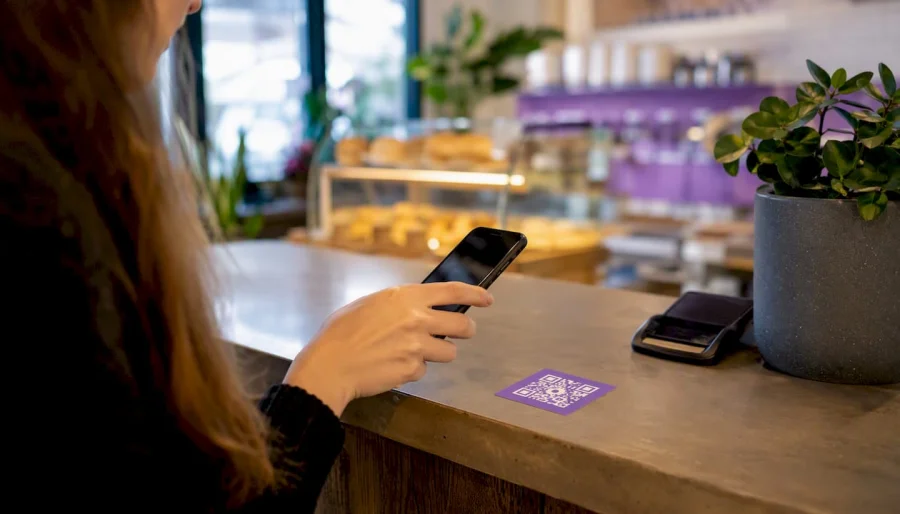 Hand scanning QR code at retail counter