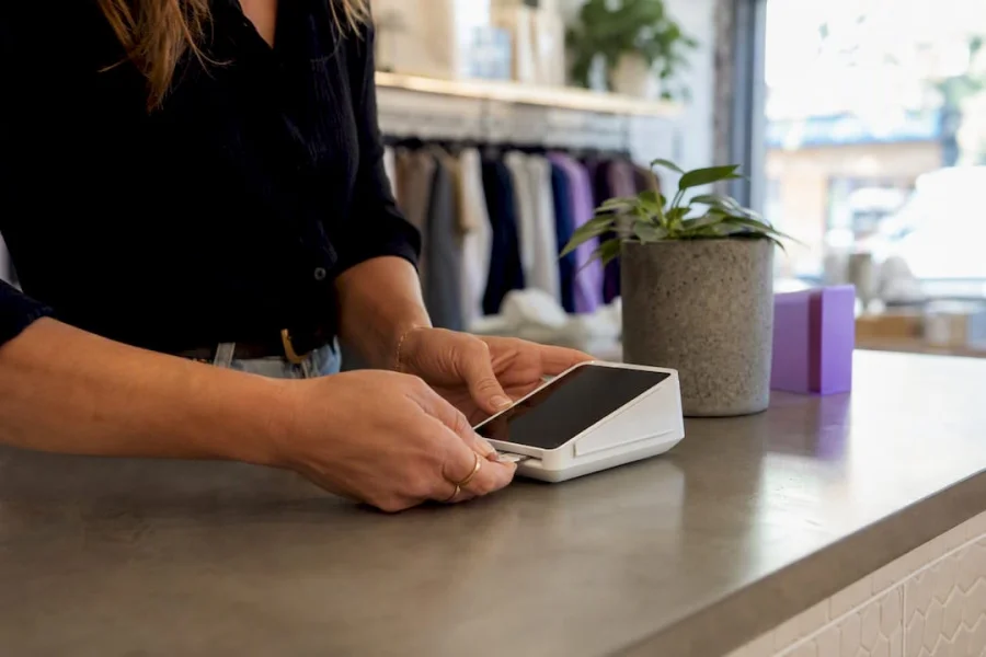 Hands connecting card reader device in store