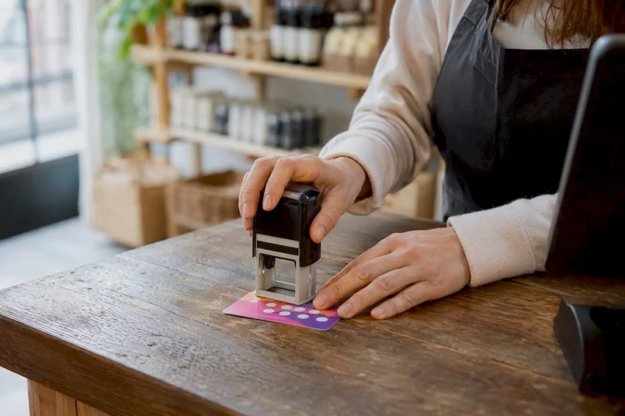 Manos sellando una tarjeta de fidelizaci&oacute;n en una peque&ntilde;a tienda