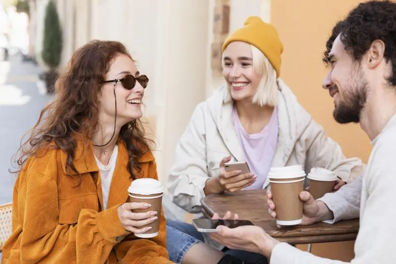 group of people sitting at the café and talking about loyalty program which coffee shop offers