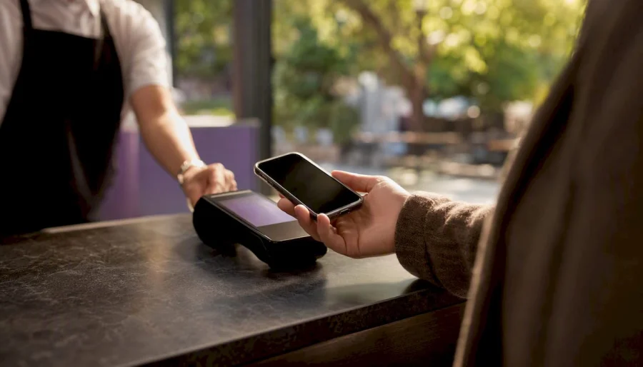 Usuario presentando un pase de fidelizaci&oacute;n en su wallet digital al pagar